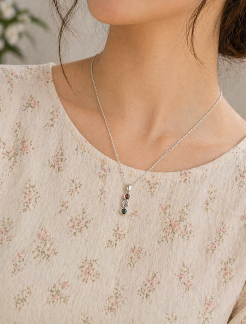Necklace with colorful beads worn by a person in a floral blouse